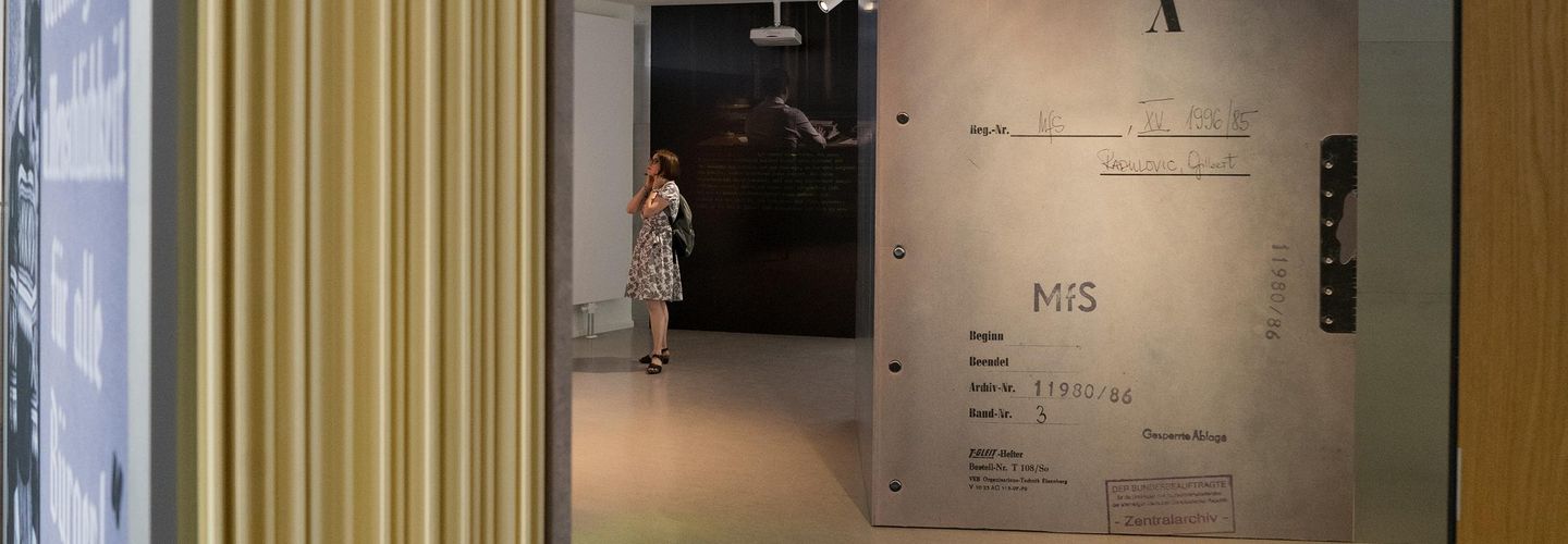 Blick in die begehbare Akte: Eine Frau schaut sich eine Ausstellungstafel an.