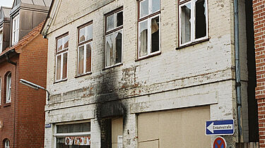 Möllner Bürger vor dem ausgebrannten Wohnhaus, in dem bei einem Brandanschlag durch rechtsextremistische Täter drei Türkinnen ums Leben kamen