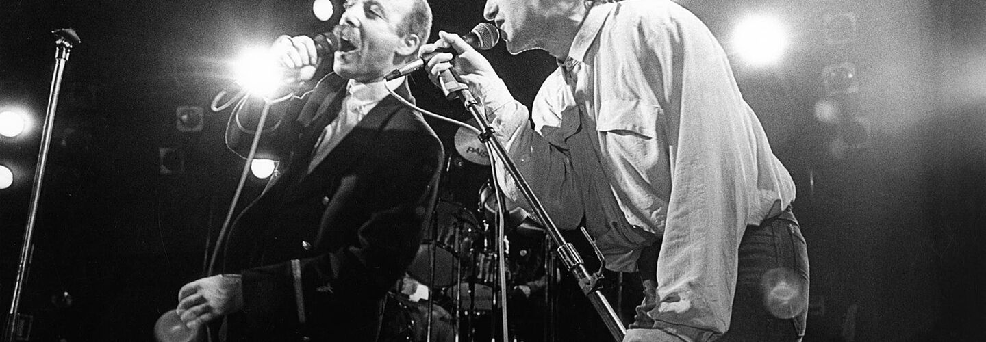 Ausschnitt aus dem Film „Soundtrack Ost“: Zwei Männer, die in ein Mikrofon singen.