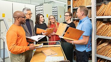 Besuchende in einem Magazinraum des Stasi-Unterlagen-Archivs