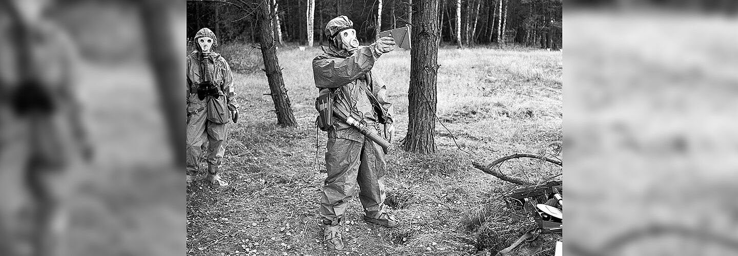 MfS-Angehörige in Schutzanzügen im Wald