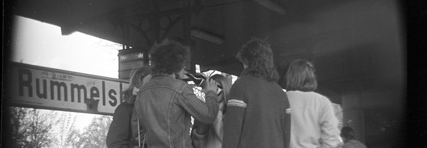 Das Schwarz-Weiß-Foto mit einem breiten Rand zeigt ein Gruppe Jugendlicher am S-Banhhof Berlin-Rummelsburg.