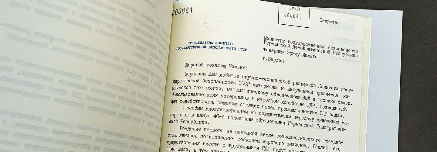 Ein Foto einer Seite der Beispielakte. Zu sehen ist ein auf Russisch geschriebener Brief mit Wappen des KGB. Zu sehen ist der obere Teil des Briefes, in dem Wladimir Krjutschkow Erich Mielke anlässlich des 40. Jahrestages der Gründung der DDR gratuliert und auflistet, welche Spionageinformationen er mitsandte.