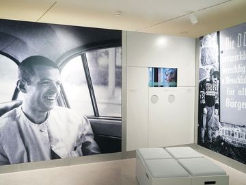 The picture shows two big pictures of Gilbert Radulovic and a screen showing an interview with Radulovic. 