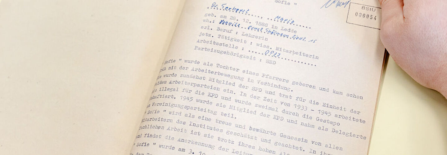 Ein Blick in die aufgeschlagene Beispielakte. Er enthält eine Beurteilung und Lebenslauf von Marie Torhorst und ihre Zusammenarbeit mit der Stasi. Am Ende wir verfügt die Akte ins Archiv zu geben.